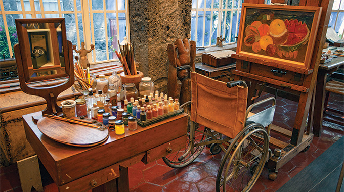A painting station with a wheelchair set up in front of an easel